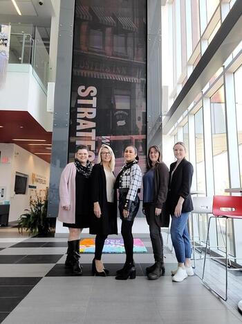 Lisa Habel, Gail Spencer, Yessenia Guerrero, Laura McDonald, and Carly Richardson in the impressive lobby of the Stratford Campus