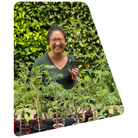 Woman holding and standing in front of plants