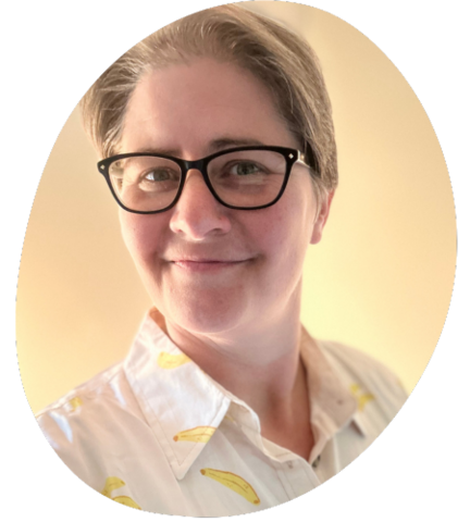 Kathy Becker in black glasses and a white collared shirt with bananas on it.