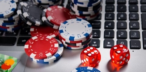 poker chips and dice on a computer keyboard