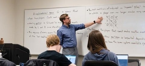Nathaniel Stevens teaching at a whiteboard