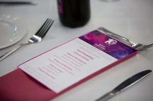 place setting with menu on white tablecloth