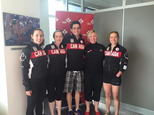 Sharleen poses with four athletes wearing Team Canada gear