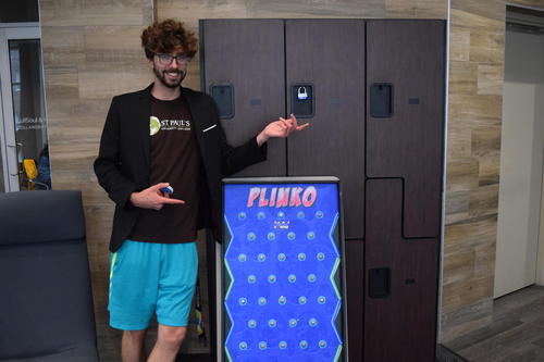 Daniel stands beside a Plinko game