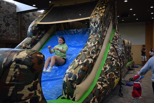 student slides down inflatable obstacle course