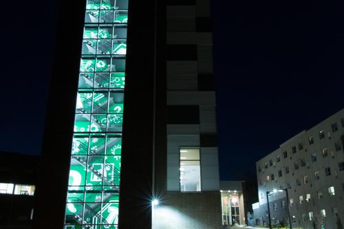 The stairwell lit up at night displaying the street style art.