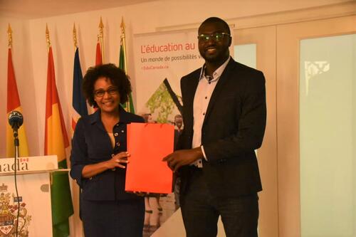 Michaëlle Jean presents Seyni Mbaye with a red folder