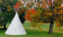 Teepee next to maple tree with red leaves