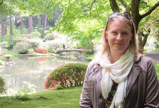 Anna Purkey with a garden and reflecting pool in the background