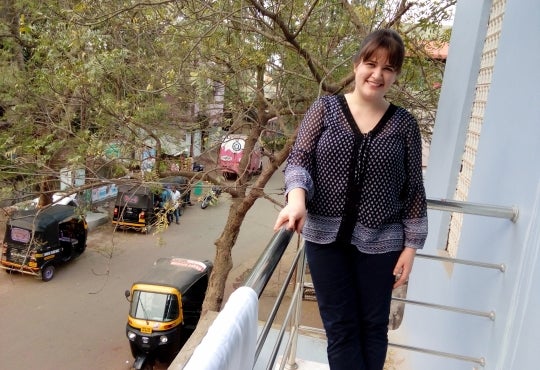 International Development grad Kaitlin Murray poses on a balcony in India