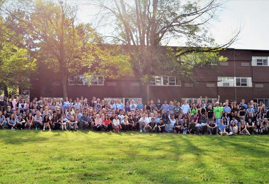 large group photo of first year St. Paul's residents during orientation week, with St. Paul's in the background