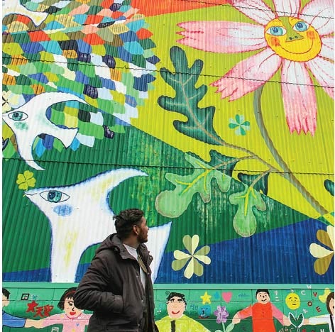 Student looking up at brightly painted wall art.
