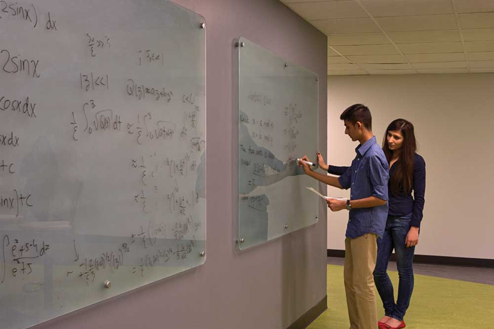 Students solving equations at whiteboard