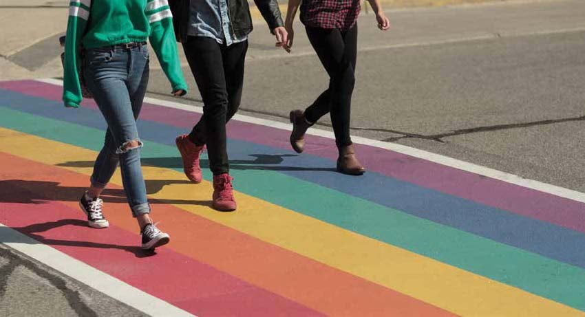 Students walk across a rainbow crosswalk on Waterloo's campus