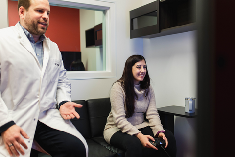 Researcher and participant playing a video game to find engaging user experiences