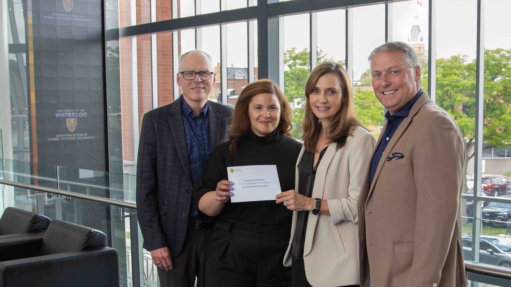 Dan Mathieson, John Wilkinson, Heidi Culliton, and Jessica Thompson holding dontation cheque.