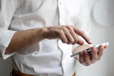 Person scrolling on smartphone in hand