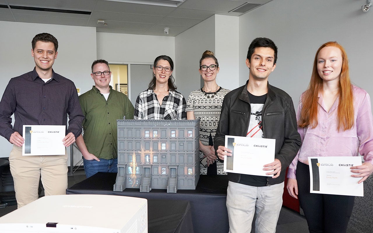 Christie® Design Award recipients, Daniel Recchia, Arturo Salek, and Emily Hunt pose in front of the Brownstones model with Arlonna Seymour and Duston Rochford of Christie® and Annaka Willemsen of University of Waterloo, Stratford School of Interaction Design and Business