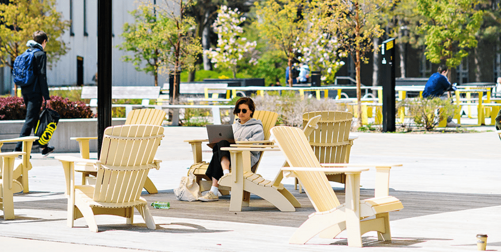 Student sits in the Arts quad working on a laptop