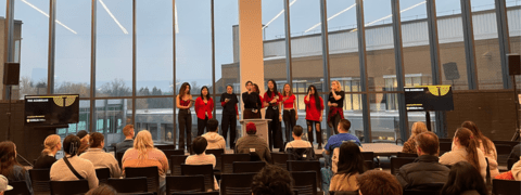 Group of 9 students performing acapella live at event