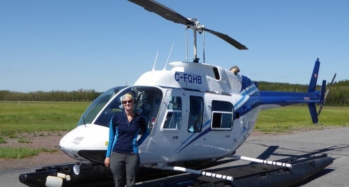 Casey Remmer in front of a helicopter