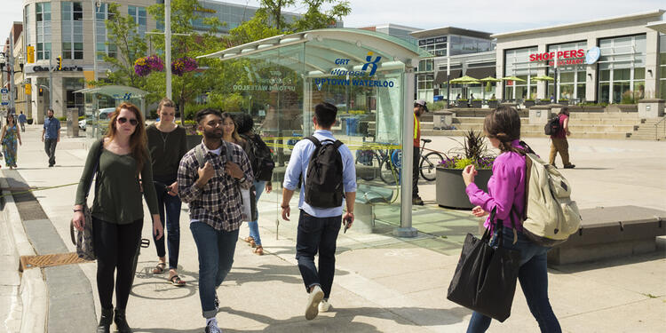 A group of students walking around Uptown Waterloo on a sunny summer day