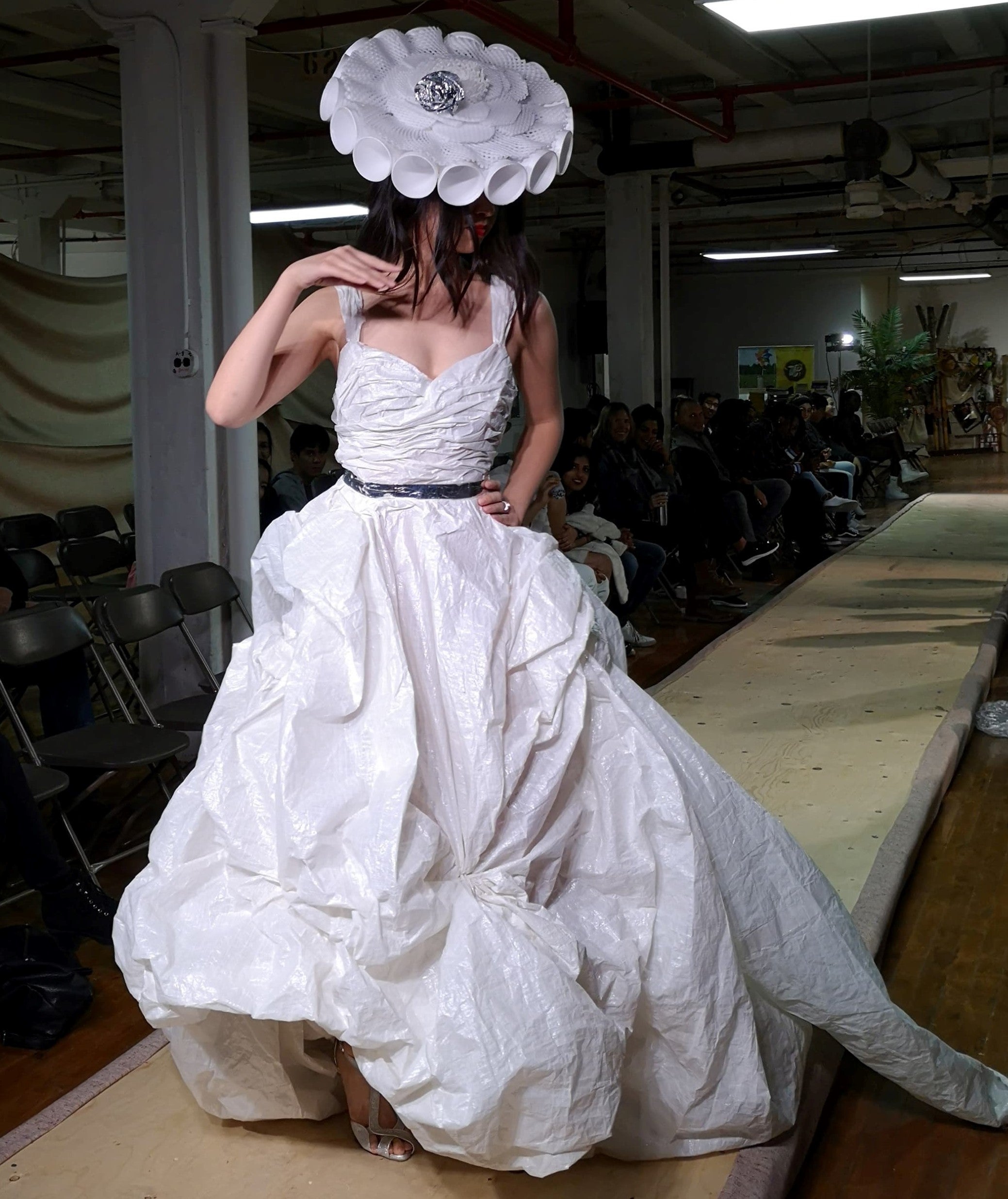 Student modelling a white dress made from sustainable material for the “Waste” segment.