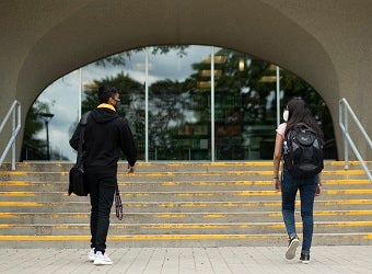 Two student walking up steps into the Dana Porter library