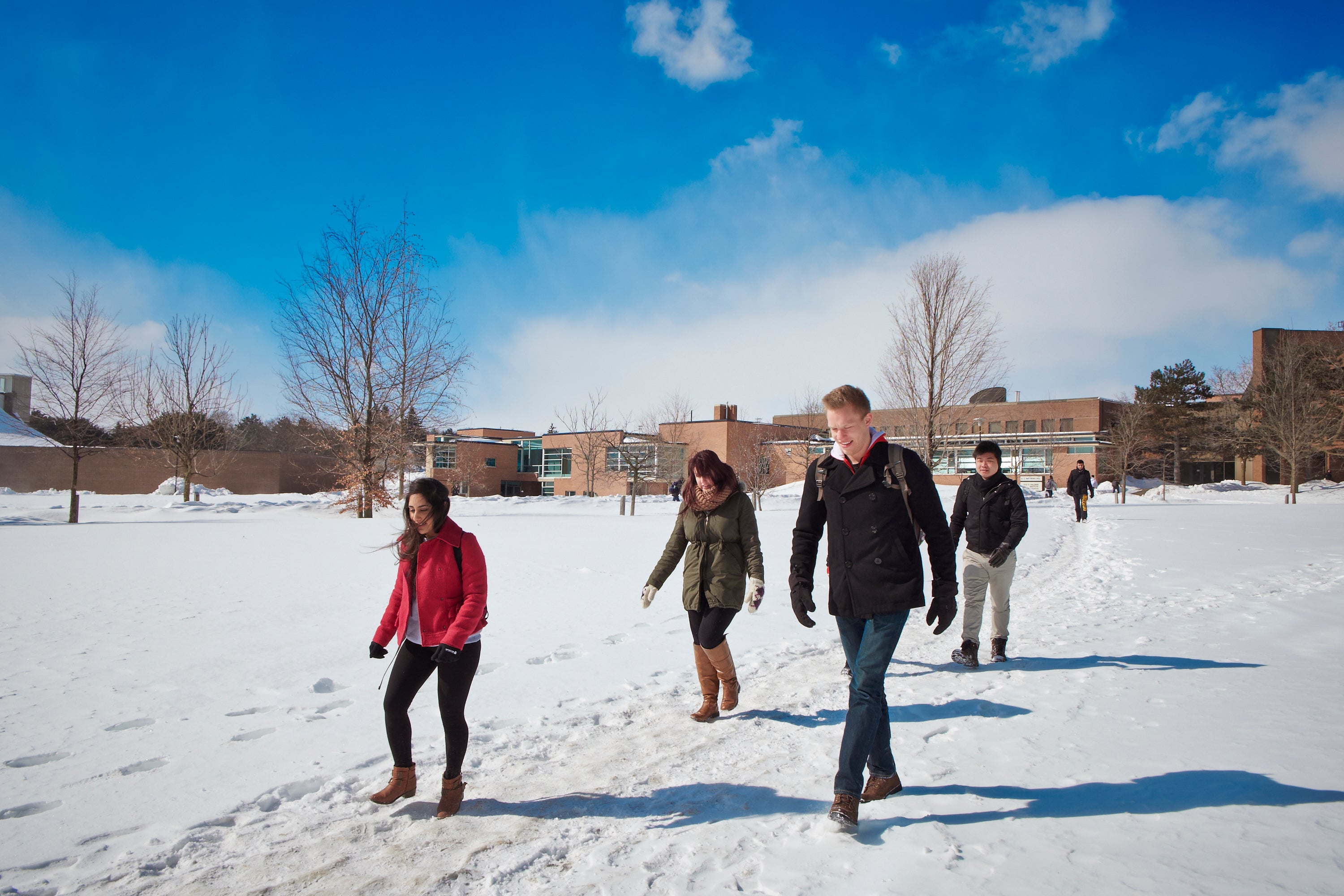 Students walking across BMH green in the winter