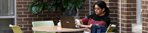 student sitting in a lounge area with laptop