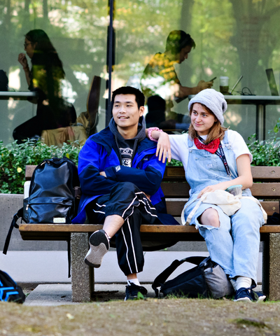 Two students sitting on a park bench in the Rock Garden