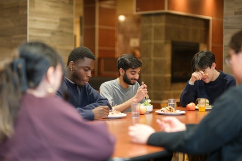 5 students eating together in United College dining room
