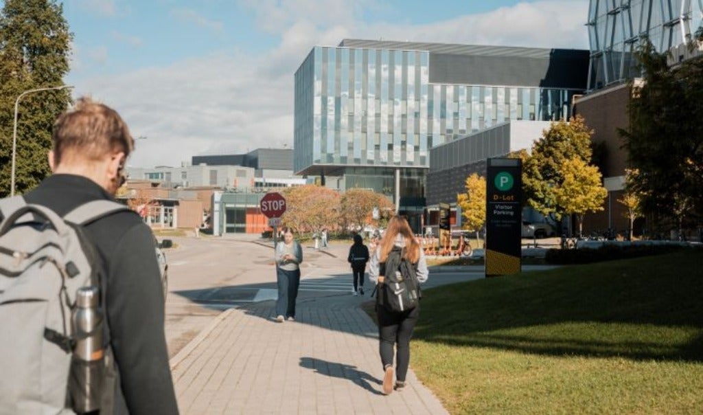 Student walking on ring road outside QNC