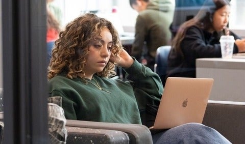 Student sitting with their laptop on their lap