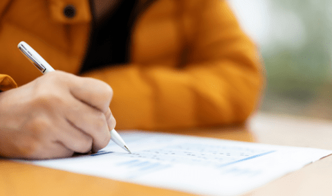 Student's hand writing an exam paper