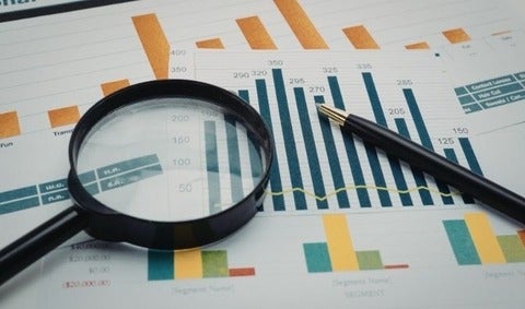 Printed graphs with a magnifying glass on top of the papers