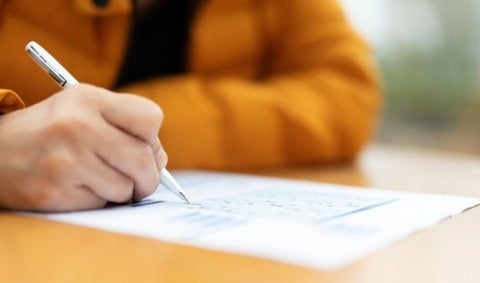 Person writing exam.