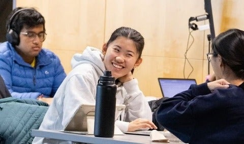 3 students studying around laptops