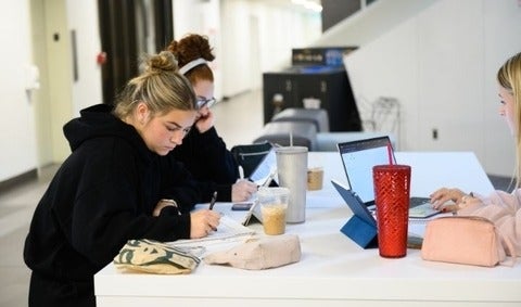 3 student studying with laptops and snacks