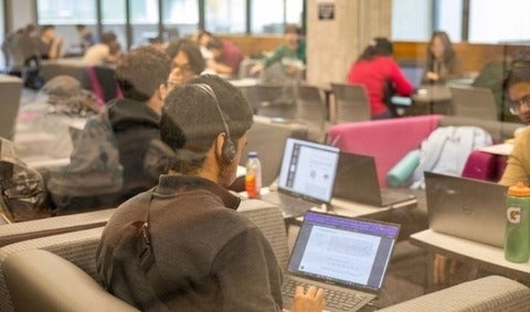 Student with on their laptop with their notes showing