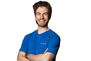 student standing with arms crossed smiling