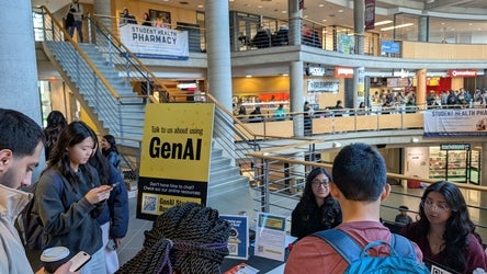 Students huddled around a boothing table in the Student Life Centre talking about using GenAI.