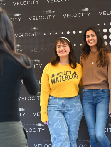 students having their photo taken with a Velocity backdrop
