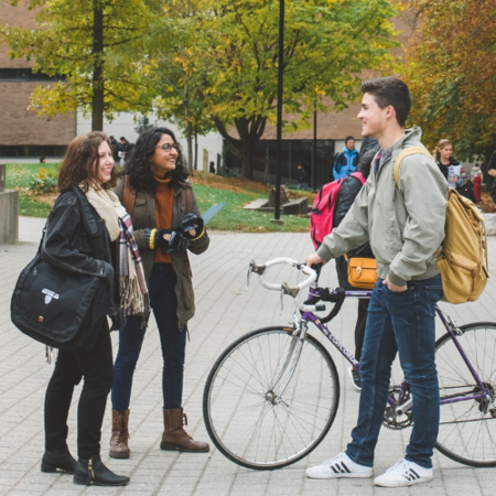 Students sharing a laugh together while walking outdoors on campus