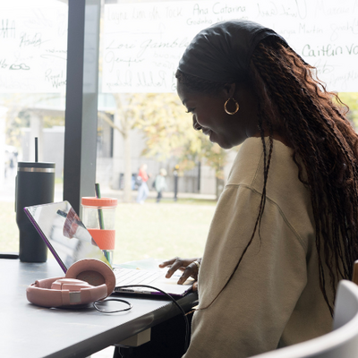 students working on a laptop in front of a window in the Student Life Centre
