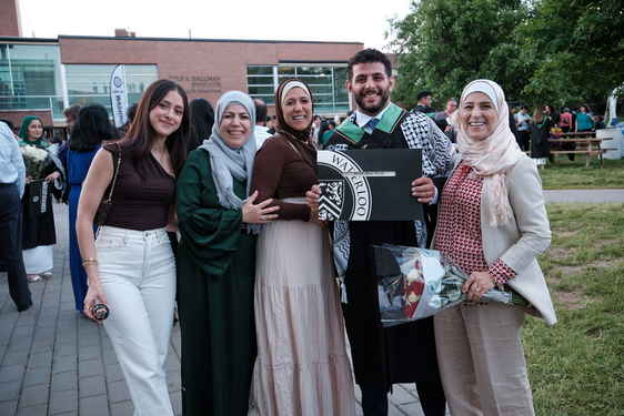 male UWaterloo student graduating at convocation with his four female family members