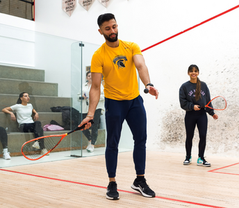 Two students playing racquetball at the PAC.