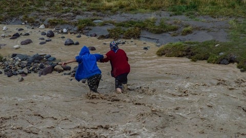 two women running in flood waters