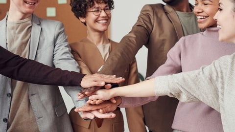 Coworkers put their hands together