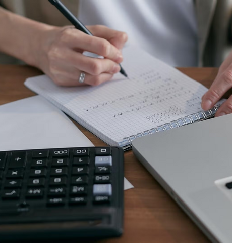 Hands writing on notebook page with a pen